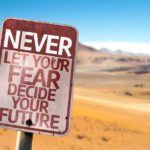 Never Let Your Fear Decide your Future sign with a desert background