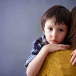 Sad little child boy hugging his mother at home isolated image copy space. Family concept