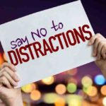 Say No To Distractions placard with night lights on background