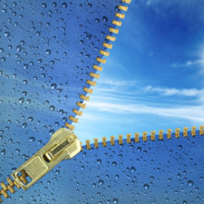 Unzipped glass with water drops revealing blue sky