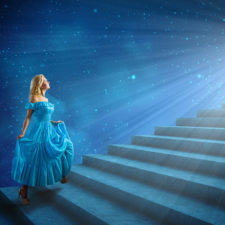 Young blond woman in blue dress walking up the stairs